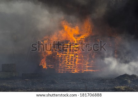 flames and smoke rise from burning building