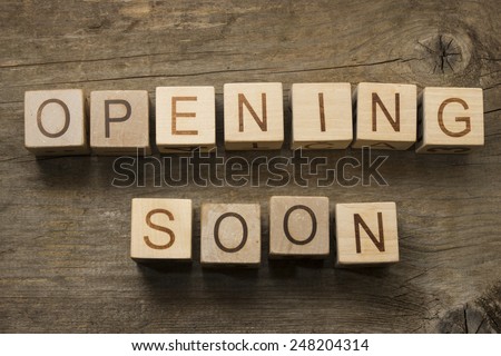 Opening soon text on a wooden cubes on a wooden background