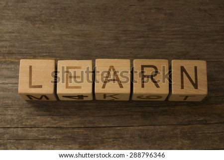 text LEARN on a wooden cubes