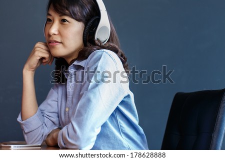 Young woman using  wireless headphone at work