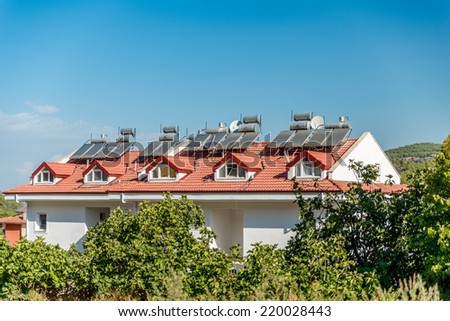 Image showing solar panels and water storage tanks on the top of houses in hisaronu, Turkey with blue sky and room for copy space