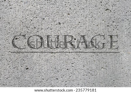 The word courage carved in stone