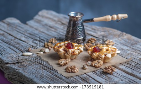 Still life, cakes, nuts and coffee pot on a wooden table