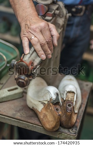 A shoemaker\'s hand and tools
