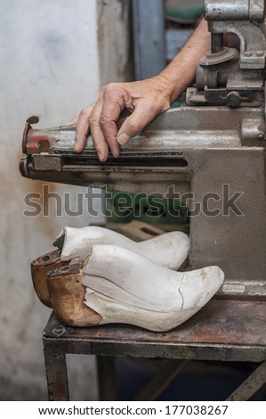 A shoemaker\'s hand and tools