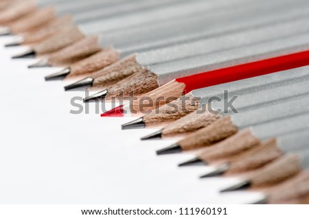 One red color pencils among lead pencils