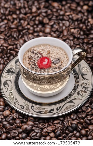 Cup of coffee with cherry  and coffee beans