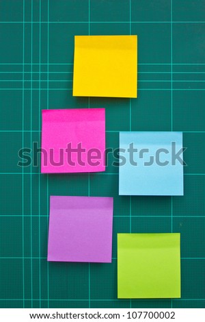 Colorful sticky notes on cutting mat.