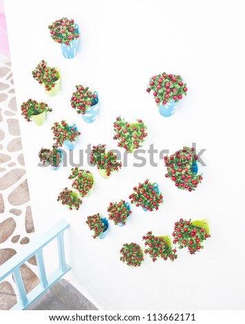 Plastic flowers with colorful plastic vase decorating on the wall.