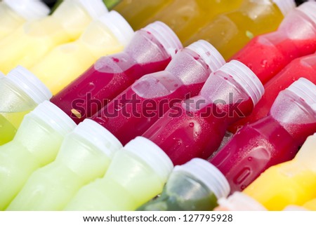Assortment of cold tropical fruit juice in bottles.