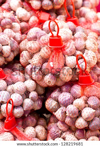 Many red onion with red net  in marketplace.