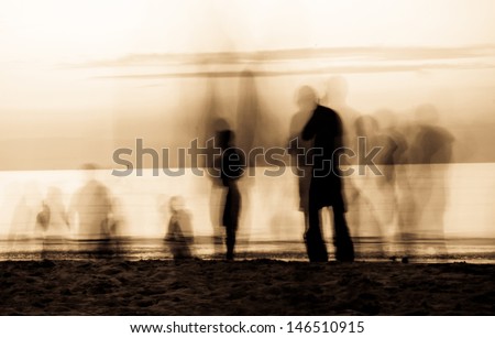 moving ghosts on the beach People walking on the beach at sunset. The movement blur makes it spooky. Duo tone