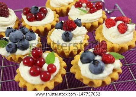 Fresh delicious fruit tarts with cream and berries