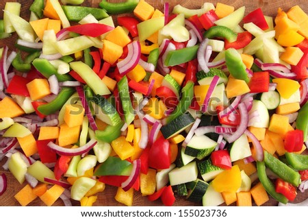 Colored peppers and onions diced on a chopping board