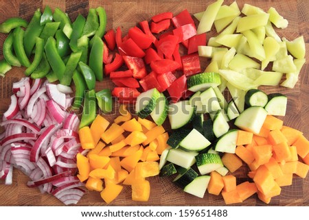 Colored Peppers And Onions Diced On A Chopping Board