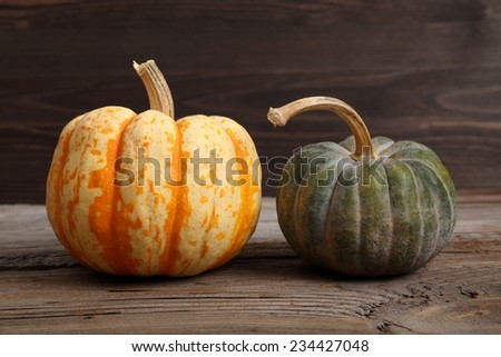 Two varieties of pumpkins on a wooden background. Autumn harvest.