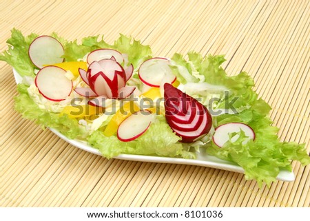 Decorative and colorful salad with lettuce, radish and peppers.