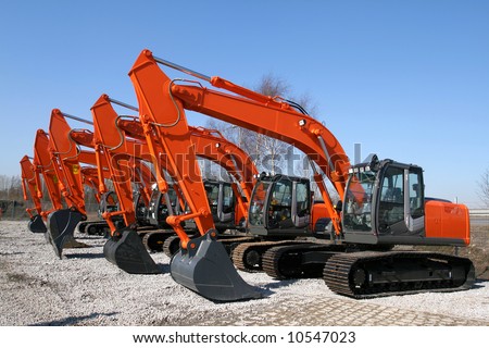 New, shiny and modern orange excavator machines. Construction industry machinery.