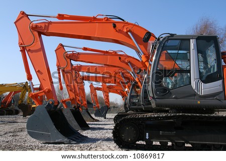 New, shiny and modern orange excavator machines. Construction industry machinery.