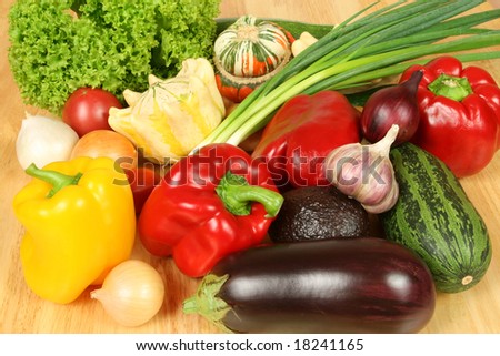 Colorful vegetables on a wooden table. Peppers, zucchini, onions and others.