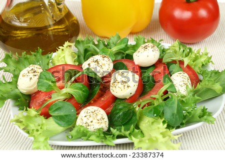 Healthy and colorful vegetable salad. Tomato, rocket plant (arugula) and mozzarella with herbs.