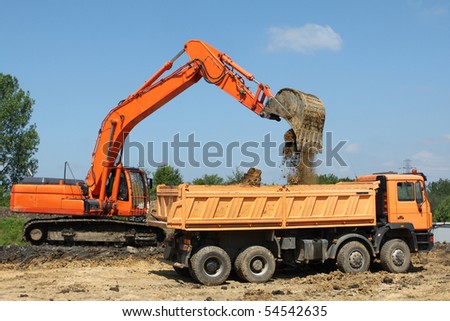 Road construction works in Poland. Heavy machinery - excavator and dump truck.