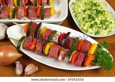 Preparation of delicious shish kebab - meat on a stick with vegetables. Meat, spices, vegetables and bacon.