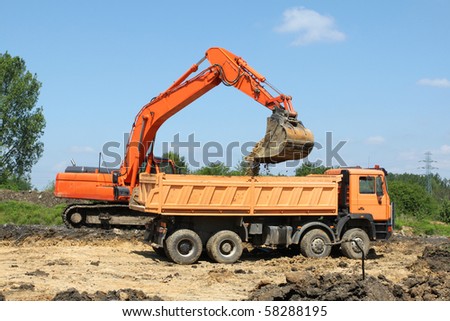 Road construction works. Heavy machinery - excavator and dump truck.