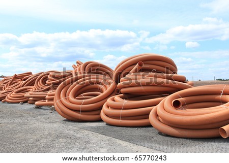 Orange plastic tubes - construction site objects. PVC sewer pipes.