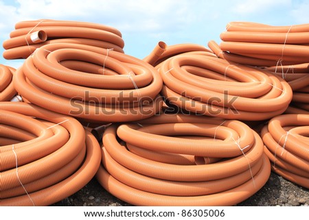 PVC sewer pipes. Orange plastic tubes - construction site objects.