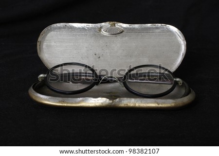 old fashioned reading glasses in metal case