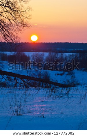 Winter sunset. Winter rural landscape with the river at sunset.