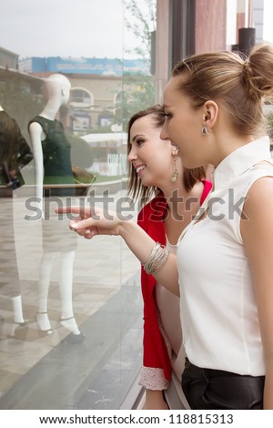 Young women looking through shop window outdoor