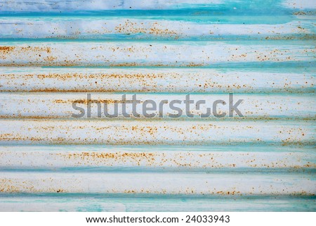 Grunge background with pale blue and white paint on old rusty corrugated metal