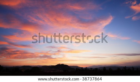 Beautiful red clouds in blue sky with silhouette of Campobasso castle