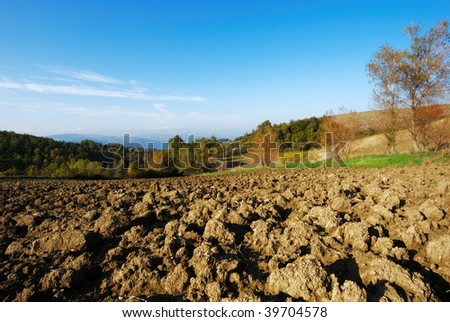 Rural autumnal landscape with plowed land and blue sky