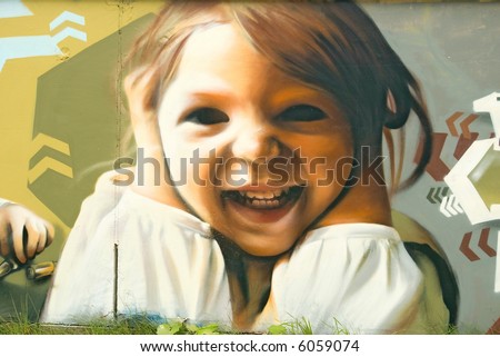 Concrete wall with young smiling girl graffiti.