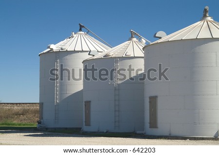 white grain bins against the blue sky