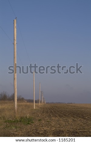 a line of utility poles against the blue sky