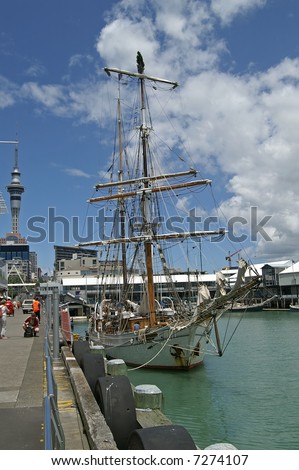Tall ship decorated with Christmas tree on top of the mast anchoring in Auckland harbor, New Zealand