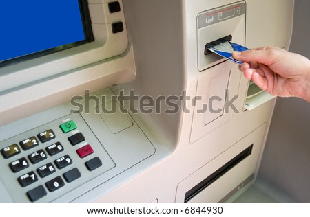 Woman accessing Automatic Teller Machine (ATM) on the street