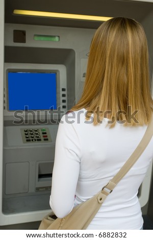 Woman accessing Automatic Teller Machine (ATM) on the street