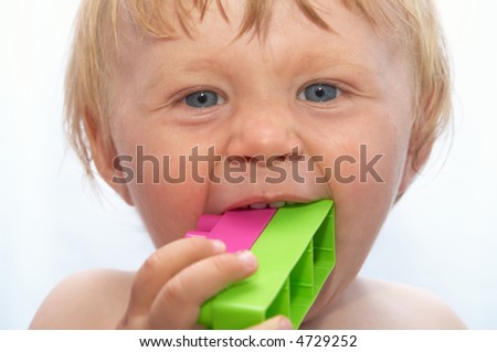 The small boy bites colour toys