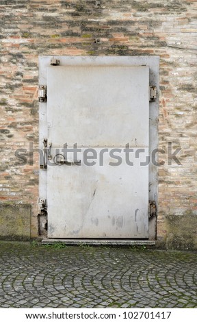weathered security door on brick wall