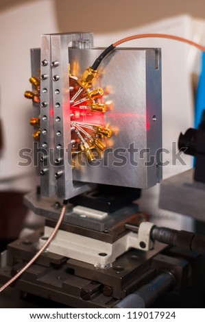 Optical device being hit by a red laser beam