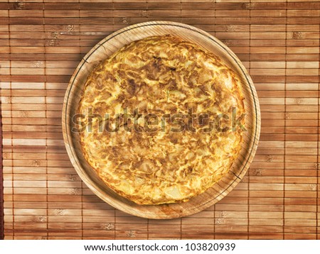Spanish tortilla on wooden plate. The tortilla is a typical dish in Spain that is prepared with olive oil, eggs and potatoes.