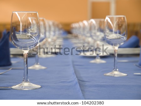 A table with a row of glasses and cutlery. The table is prepared to celebrate a special meal