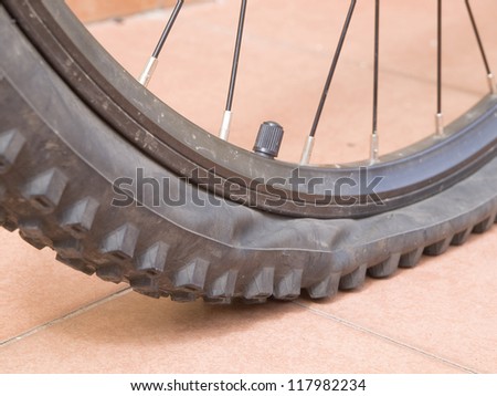 Closeup of a mountain bike wheel. The wheel is flat and has studs
