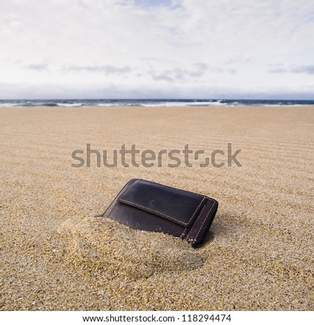 Billfold on the beach over the sand in square format