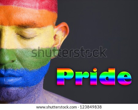 Gay flag painted on the face of a man.The man\'s eyes are closed with a serene expression on his face. The word \